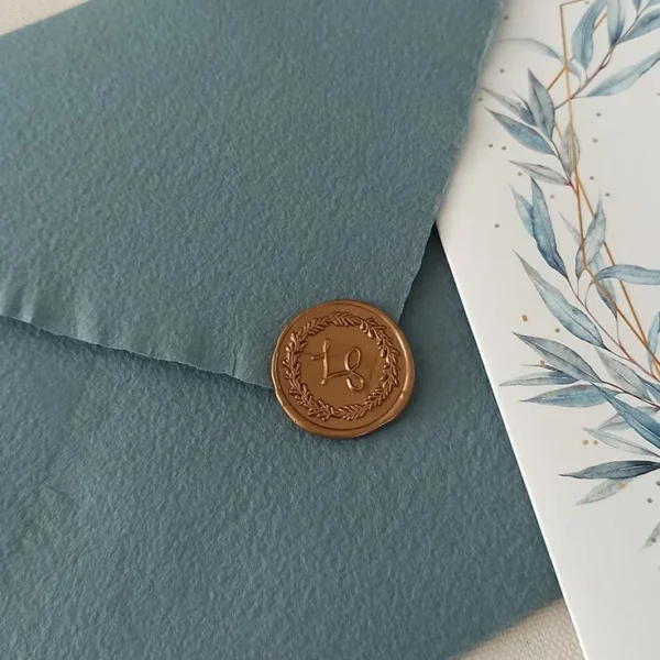 Sobre verde y sello con iniciales